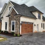creme colored house with garage doors